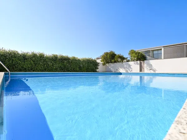Piscina em condomínio privado no terraço, com vista para o céu e rodeada de vegetação, garantindo privacidade.
